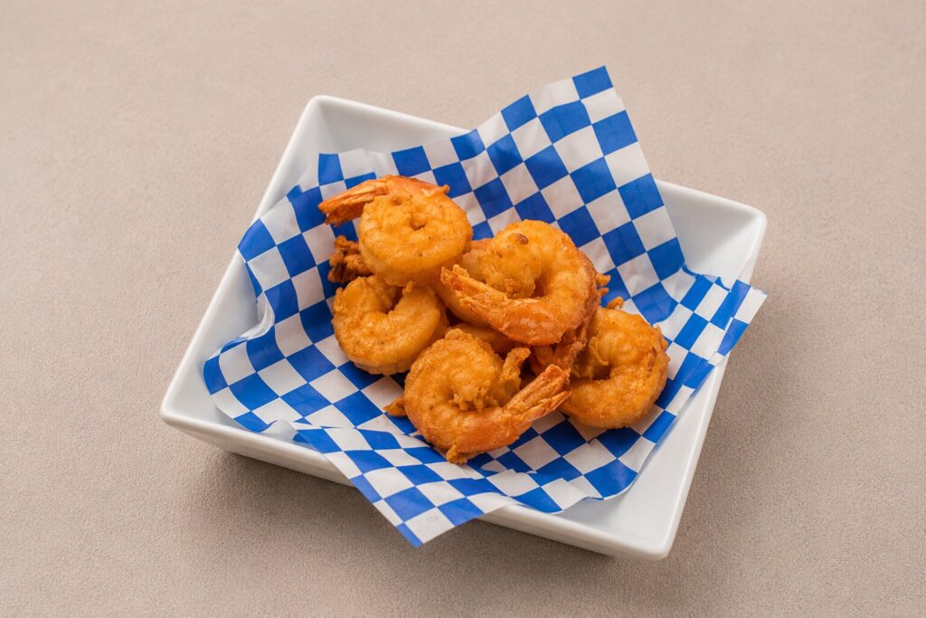 Golden-fried shrimp served hot and fresh, perfect for pairing with your favorite drink.